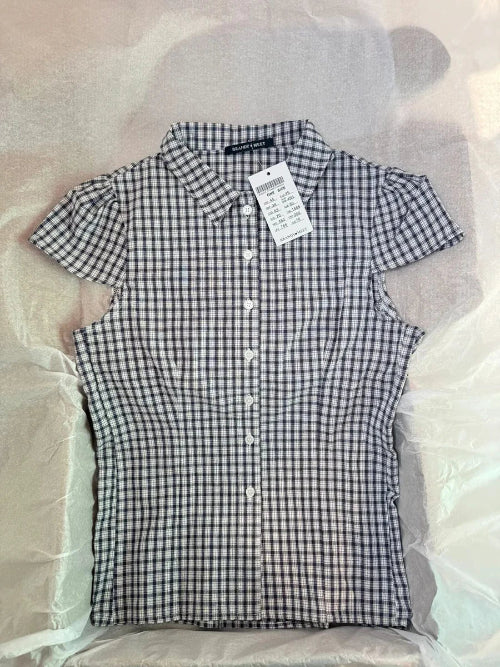 Black and white checkered shirt with a tag on a light gray background
