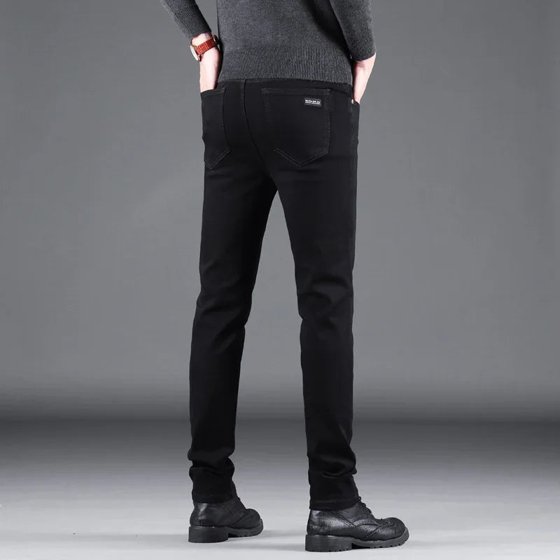 Person wearing black pants against a gray background