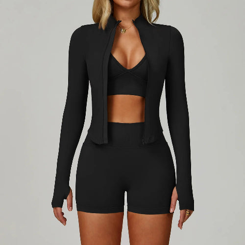 Black outfit with jacket, top, and shorts on a gray background