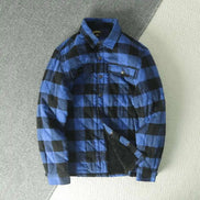 A blue and black buffalo plaid quilted overshirt jacket with a fleece lining, laid flat on a textured gray and white background.