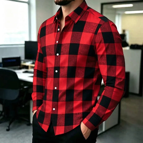 A man wearing a red and black buffalo plaid long-sleeve button-down shirt, standing in an office environment.