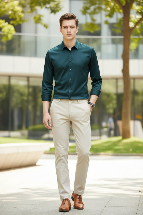 Person wearing a dark green shirt with rolled-up sleeves against a black background