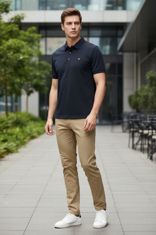 Dark blue shirt with red stitching on a hanger, held by a hand.