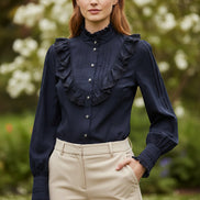 Black blouse with ruffled shoulders and cuffs on a white background
