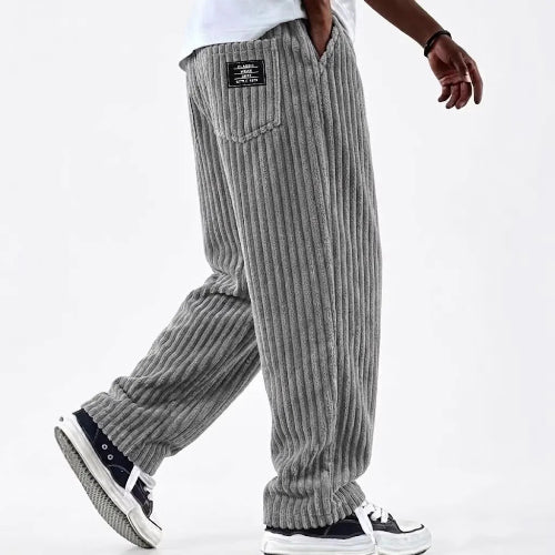 Person wearing gray corduroy pants on a white background