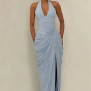 A woman modeling a light blue halter-neck maxi dress with a deep V-neckline, gathered ruching 