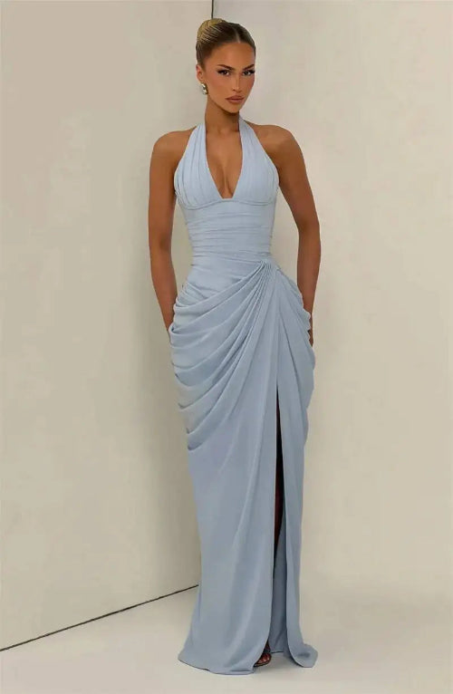 A woman modeling a light blue halter-neck maxi dress with a deep V-neckline, gathered ruching 