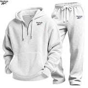 A Reebok two-piece tracksuit set featuring a white waffle-knit pullover hoodie with a half-zip front and matching jogger pants, 