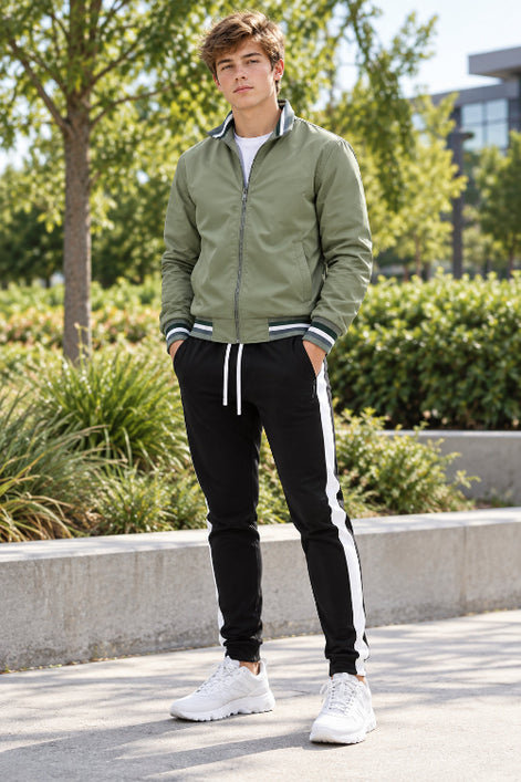 A men's two-piece tracksuit set featuring an olive green zip-up bomber jacket with striped ribbed trim and black track pants 