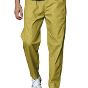 A person wearing slim-fit mustard yellow trousers, a dark gray t-shirt, and white sneakers, shown from the waist down against a plain white background.