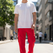 Person wearing red cargo pants and white sneakers on a light gray background