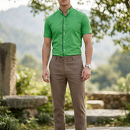 A bright green men's short-sleeve button-up shirt with a mandarin collar, black inner placket, and white buttons, shown on a plain white background.