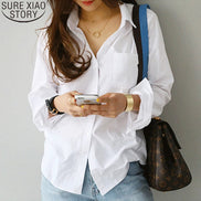 White long-sleeve button-down shirt worn by a model holding a phone.