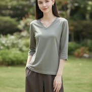 Woman wearing a gray t-shirt with a neutral background