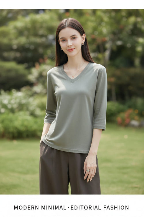 Woman wearing a gray t-shirt with a neutral background
