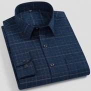 A folded navy blue long-sleeve dress shirt with a subtle tan windowpane plaid pattern, shown on a clean white background.