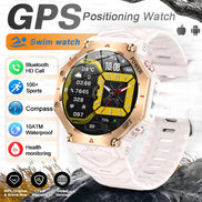 GPS positioning watch with white band and gold accents on a rocky background