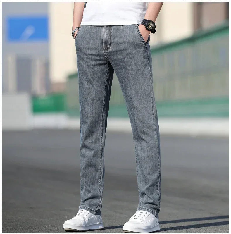Person wearing gray jeans and white sneakers on a blurred outdoor background