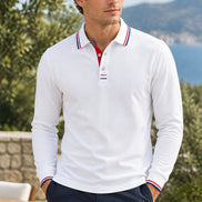 A white long-sleeve polo shirt with a double collar and striped trim in red, white, and blue on the collar 