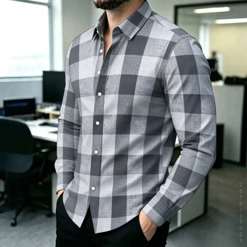 A man wearing a long-sleeve button-up shirt with a gray and white checkered pattern, standing in an office environment.