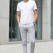 Person wearing light gray pants and brown shoes on a white background