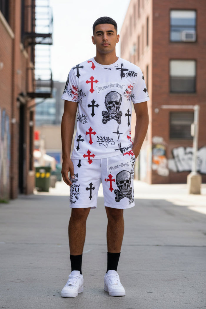 Person wearing white shorts with red crosses and black text, paired with white sneakers on a white background.