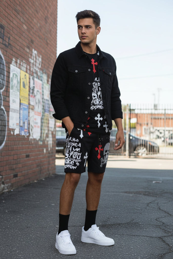 Person wearing black shorts with graphic designs and white sneakers on a white background