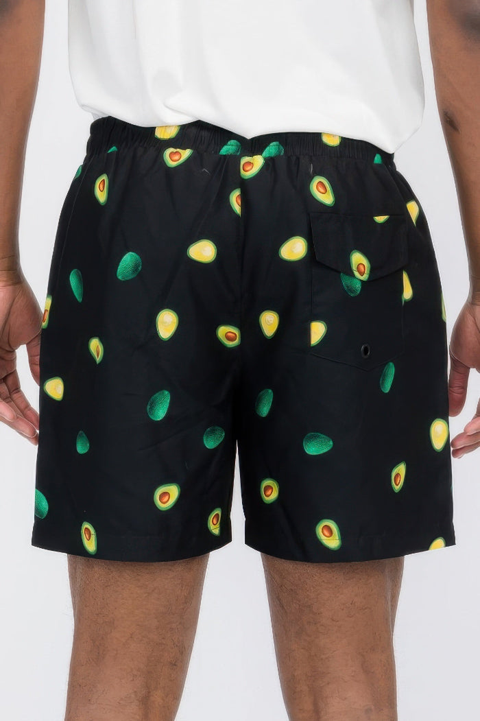Black shorts with avocado pattern worn by a person on a white background