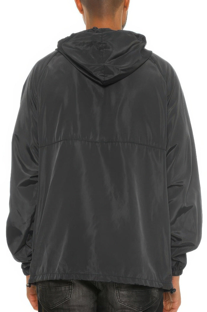 Person wearing a black hooded jacket on a white background