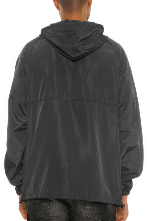 Person wearing a black hooded jacket on a white background