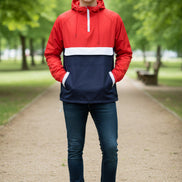 Person wearing a red and navy anorak jacket on a white background