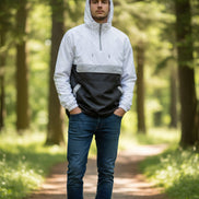 Person wearing a white and black jacket with a transparent panel over the chest on a white background