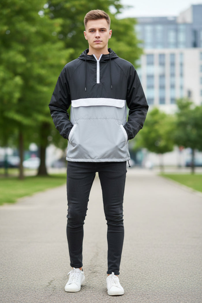 Person wearing a black and white half-zip jacket on a white background