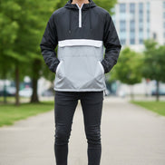 Person wearing a black and white half-zip jacket on a white background