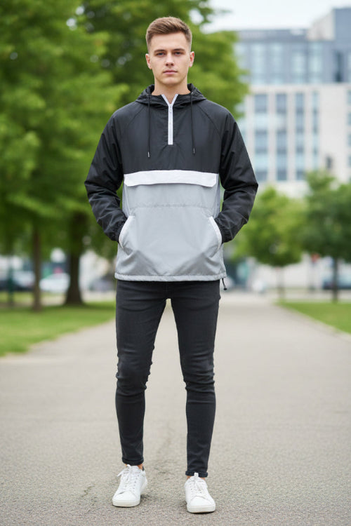 Person wearing a black and white half-zip jacket on a white background