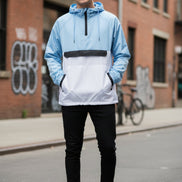 Person wearing a light blue and white jacket with black accents on a white background