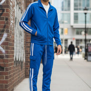 Person wearing a blue tracksuit with white stripes  taken outside