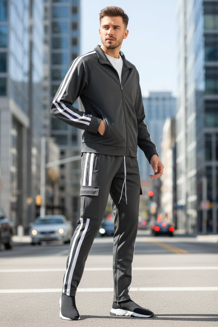 Man wearing a gray tracksuit with white stripes  taken outside