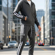 Man wearing a gray tracksuit with white stripes  taken outside