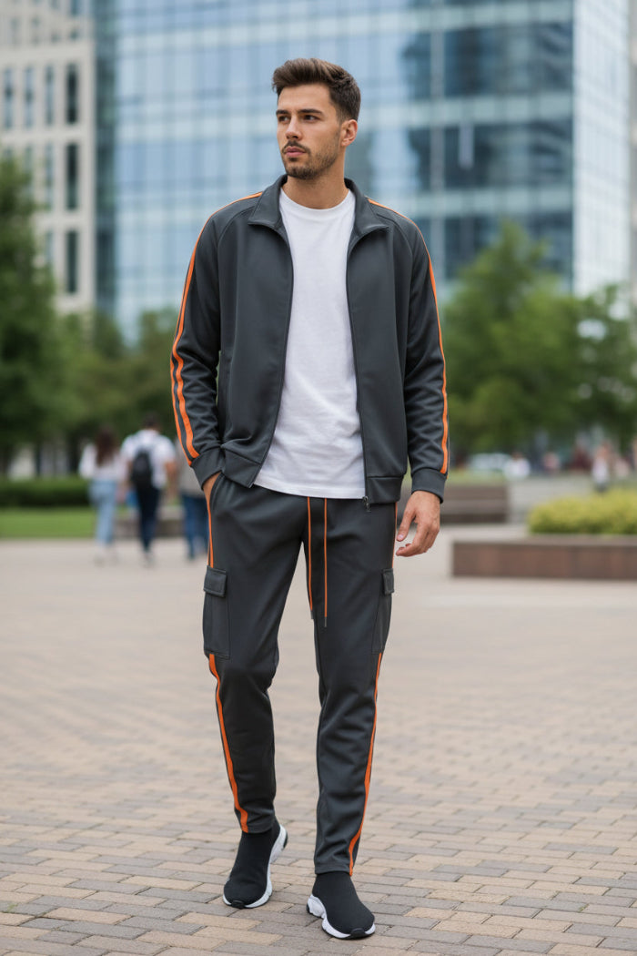 Man wearing a gray tracksuit with orange stripes  taken outside