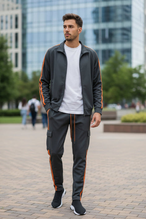 Man wearing a gray tracksuit with orange stripes  taken outside
