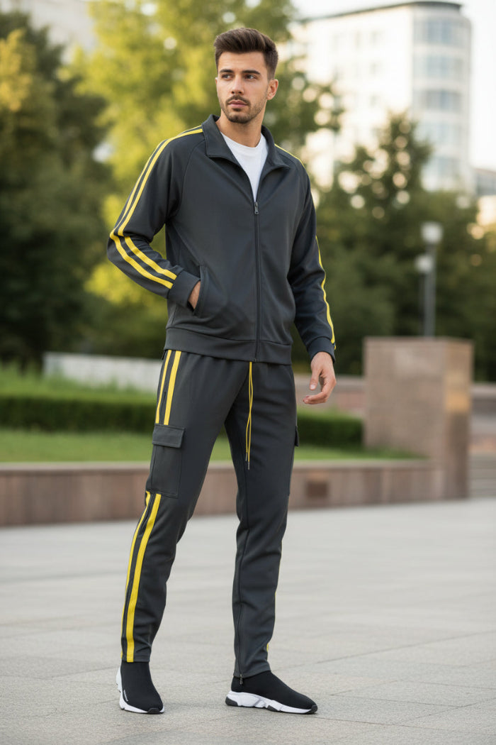 Man wearing a gray tracksuit with yellow stripes taken outside