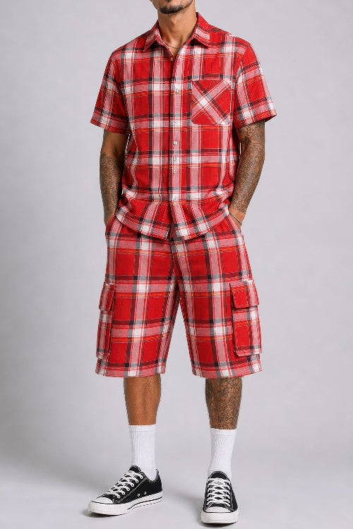 Person wearing a red plaid outfit with black Converse shoes on a gray background