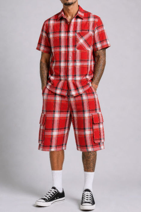 Person wearing a red plaid outfit with black Converse shoes on a gray background
