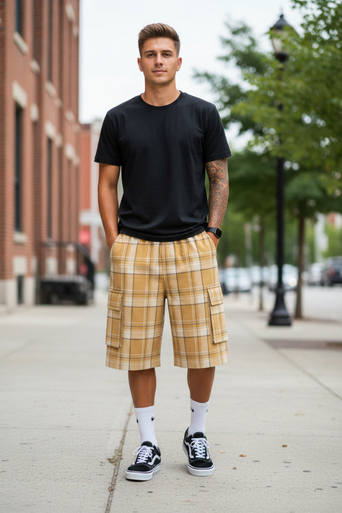 Person wearing plaid shorts and black sneakers on a white background