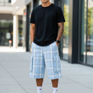 Person wearing light blue plaid shorts with pockets on a white background