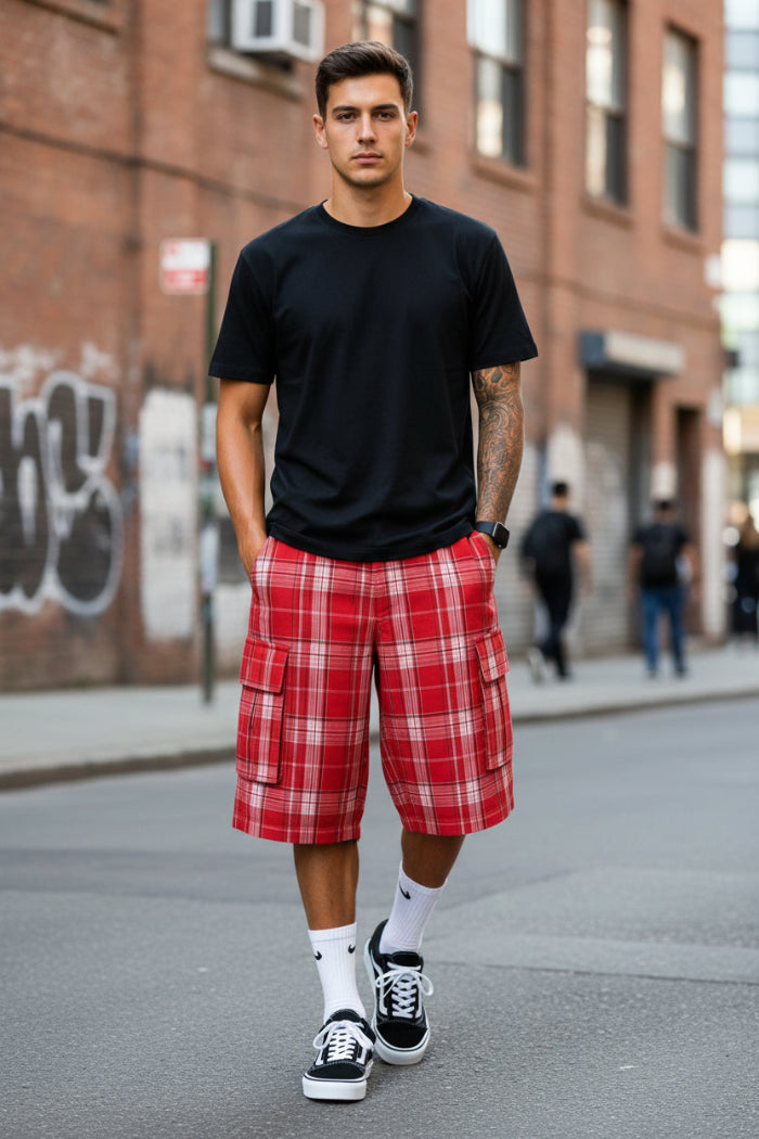 Person wearing red plaid cargo shorts with a white background