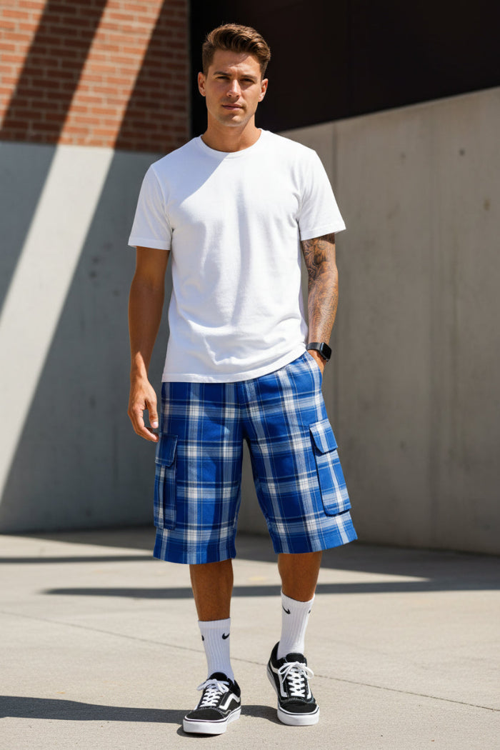 Person wearing blue plaid shorts, white socks, and black sneakers on a white background