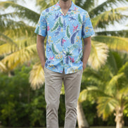 Man wearing a colorful tropical pattern shirt on a white background
