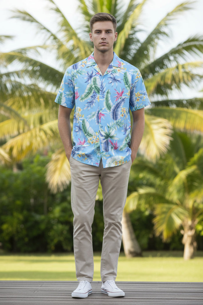 Man wearing a colorful tropical pattern shirt on a white background